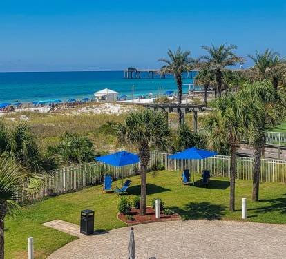 Wide view of the beachside pool area framed by tropical scenery.