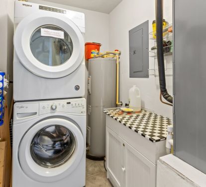 Private laundry room with stacked washer and dryer. 