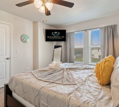 Relax in this serene bedroom featuring a plush bed, stylish wood headboard, smart TV, and soft natural light. Thoughtfully designed for comfort and rest, it&rsquo;s the perfect retreat after a day of adventure or work.