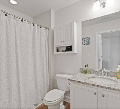 Bright and spotless bathroom vanity with granite countertop, large mirror, and extra storage. Thoughtfully stocked with essentials and fresh towels for a comfortable, convenient stay.