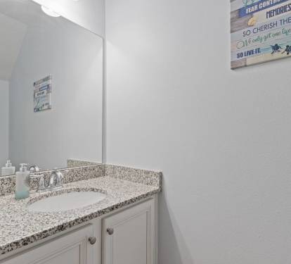 Bright and spotless bathroom vanity with granite countertop, large mirror, and extra storage. Thoughtfully stocked with essentials and fresh towels for a comfortable, convenient stay.