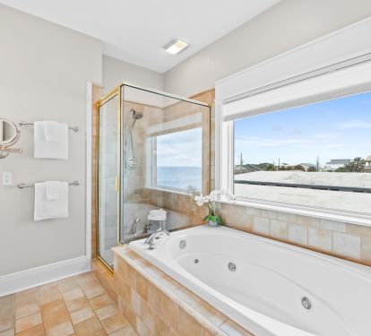 Indulge in spa-like relaxation in this ensuite with a jetted tub, walk-in shower, and water views. After a day at the beach, nothing compares to unwinding in your private retreat with luxury finishes.