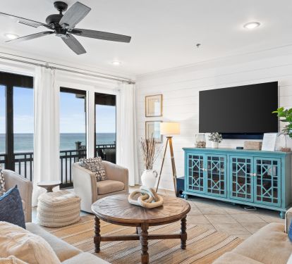 Stylish Gulf-view living room with modern coastal d&eacute;cor and large TV&mdash;perfect for relaxing after a day at the beach while still enjoying the breathtaking views right outside your window.