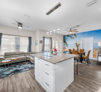Quartz countertop Kitchen island with 4 bar height chairs along with Dining table with 4 chairs. There are 8 seating arrangements