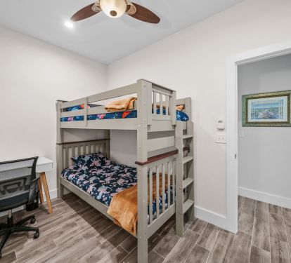 Twin over Twin bunk bed with office desk and ergonomic chair for your remote work needs.