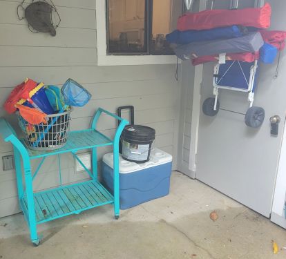 Beach toys, rolling cooler, beach chairs, and a beach cart provided.