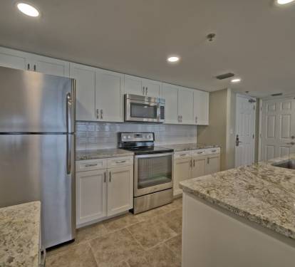 Newly renovated kitchen with granite, large sink, island bar seating, stainless