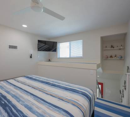 Relax in the master bedroom king bed, cozy linens, and a one-of-a-kind Popeye theme with coastal striped flooring.