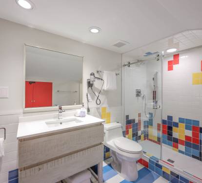 Fresh, stylish master bath with a walk-in shower and playful, colorful tilework that makes the space pop.