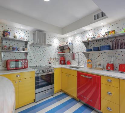 Sunny, retro kitchen with bright yellow cabinets, Smeg appliances.
