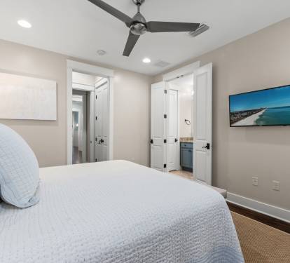 Spacious bedroom w/ ceiling fan, wall-mounted TV & easy access to the en-suite bath.