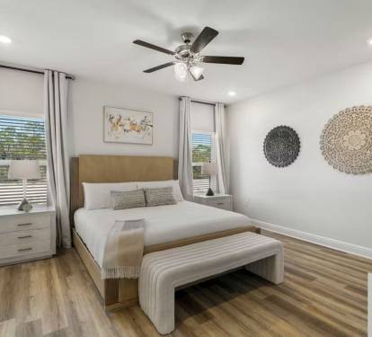 Bedroom 3: Comfort meets style with a ceiling fan, bedside lamps, and decorative artwork.