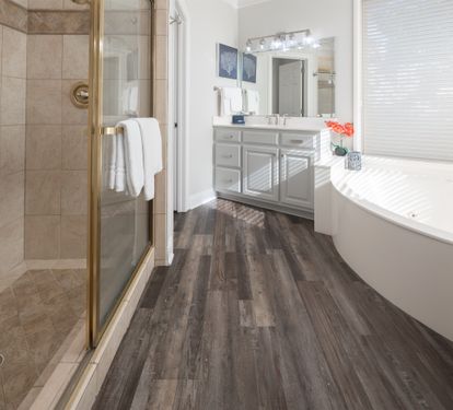 Relaxing bathroom w/ a soaking tub and glass-enclosed shower, finished in warm, neutral tones.