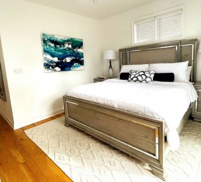 The nicely appointed primary suite offers an ensuite bath and a wonderfully comfortable king size bed. It offers a ceiling fan, a full-size mirror, and a bedroom set with triple dresser and nightstands.