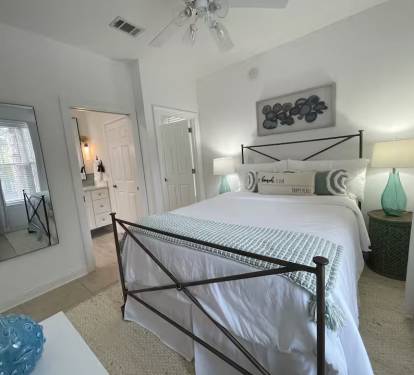Downstairs bedroom offers an ensuite bath. Find a comfortable queen bed, closet, chests of drawers, a ceiling fan and full-size mirror. 