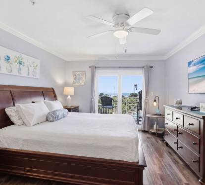 Primary bedroom with beach views and balcony access