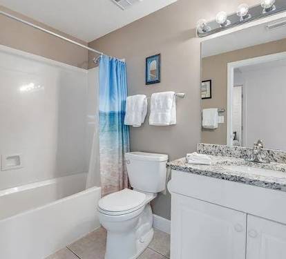 Bright guest bathroom with granite vanity&mdash;clean, coastal, and thoughtfully stocked