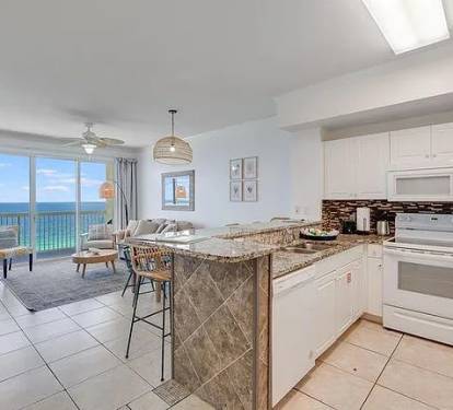 Bright coastal kitchen with bar seating and stunning Gulf views