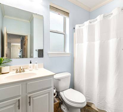 A second full bathroom stocked with soaps and shampoo.