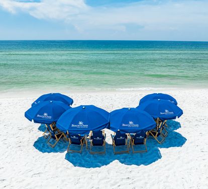 Pristine white sand beach with turquoise Gulf waters and resort-branded beach setup ready for your arrival.