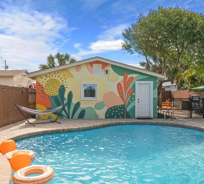 Dive into your private pool the moment you arrive! The freeform backyard oasis is yours all week, with loungers, umbrellas, hammock stand, and a vibrant tropical mural setting the mood.
