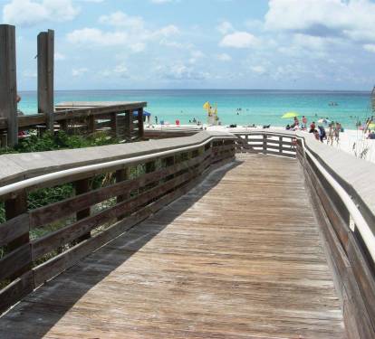 Scenic wooden boardwalk leading straight to sugar-white sand & clear emerald water