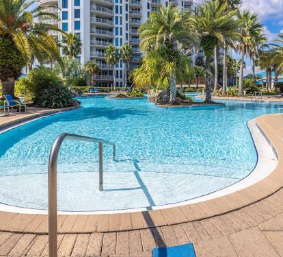 Resort-style pool framed by swaying palms, perfect for sunny afternoons & cooling off between beach days
