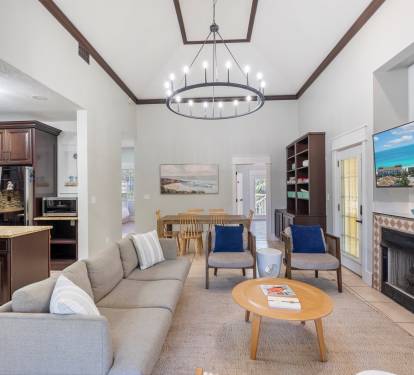 The living room is open to the kitchen and dining area and is surrounded by a wrap around enclosed porch