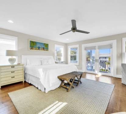 Fresh and airy master suite with comfortable king bed and deck access.