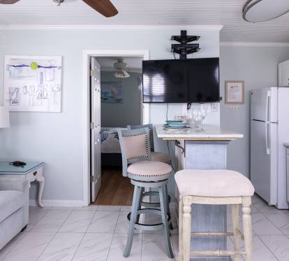 The main room brings everything together in one open, comfortable space. From the sofa to the dining island and kitchen, it’s easy to move through the condo, unpack, and settle in without feeling crowded.