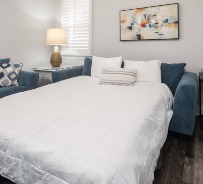Light-filled bedroom w/ a fresh, welcoming setup.