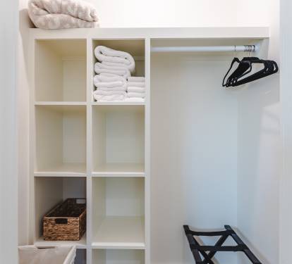 Walk In Closet complete with Hamper, Luggage Rack, Hangers, Throw Blanket, & Towels. 