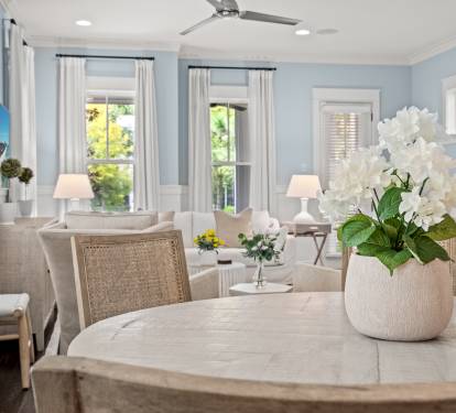 Dining table detail w/ soft florals & a view into the inviting living area beyond.