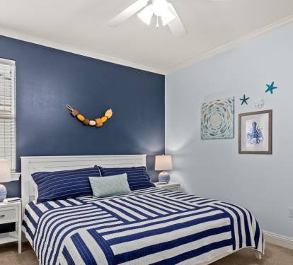 A king bed in crisp navy stripes with coastal touches that whisper "sleep in.
