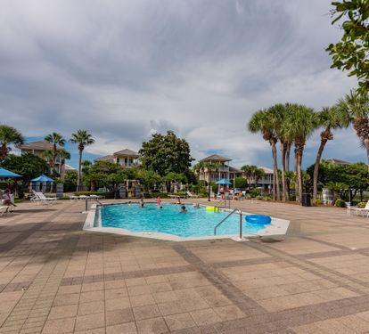 Resort-style pool area with umbrellas and seating