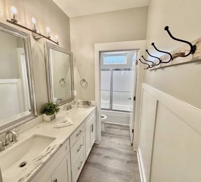 Upstairs bathroom with double vanity and shower/tub combo