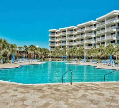 Resort-style pool surrounded by palm trees, perfect for cooling off after a sunny beach day.