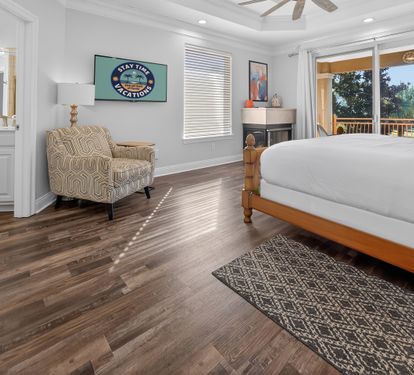 Cozy bedroom featuring a neatly made bed and warm, welcoming tones.