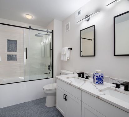 "Indulge in the master bathroom’s spa-like ambiance, complete with a double vanity, modern fixtures, and a sleek glass-enclosed shower/tub combination. ??? #LuxuryLiving #CoastalComfort"