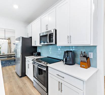 Stainless Steel Appliances w/ Various Kitchen Essentials for Your Personal Experience. Cookware and Silverware are All Stored in the Custom Cabinets