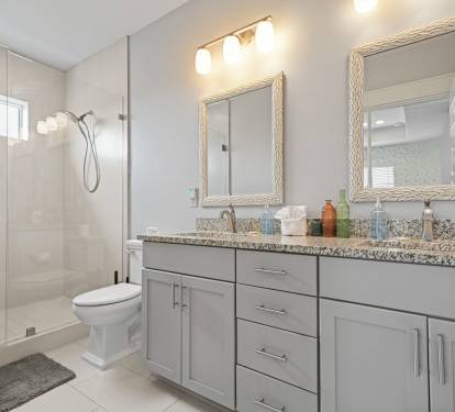 Spacious Grand Master ensuite bath with double vanity, granite countertops, and walk-in shower.