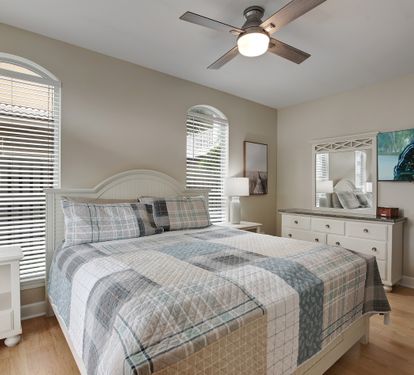  King bedroom with coastal bedding and natural light