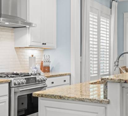 Kitchen detail highlighting the gas cooktop, tile backsplash & polished granite counters.