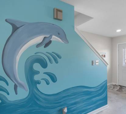 Playful dolphin mural adds a splash of coastal charm to this bright and welcoming entryway