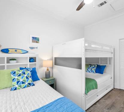 A beach-themed bunk room has a full-over-full bunk plus twin to accommodate 3-4.