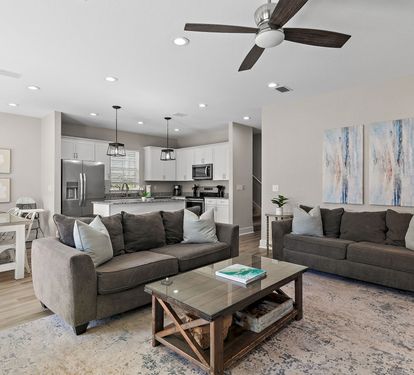 The open-concept living area includes a kitchen island, dining space, and kitchen.