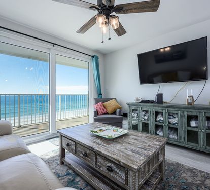 Living Room with Breathtaking Views Relax in this stylish living area, featuring plush seating, coastal decor, and a large flat-screen TV. The sliding glass doors lead to your private balcony,