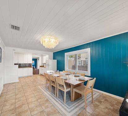 The dining room table seats 8 under a teal shiplap accent wall and
chandelier. A warm, well-lit space that earns its keep on seafood nights.
