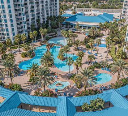 Bird’s-eye view of the palm-filled pool complex, a true resort-style centerpiece below
