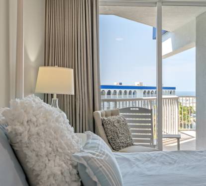 Bedroom w/ large windows and balcony access for a light, airy feel.